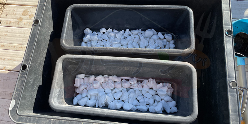 プランターに鉢底石を敷き詰めている様子